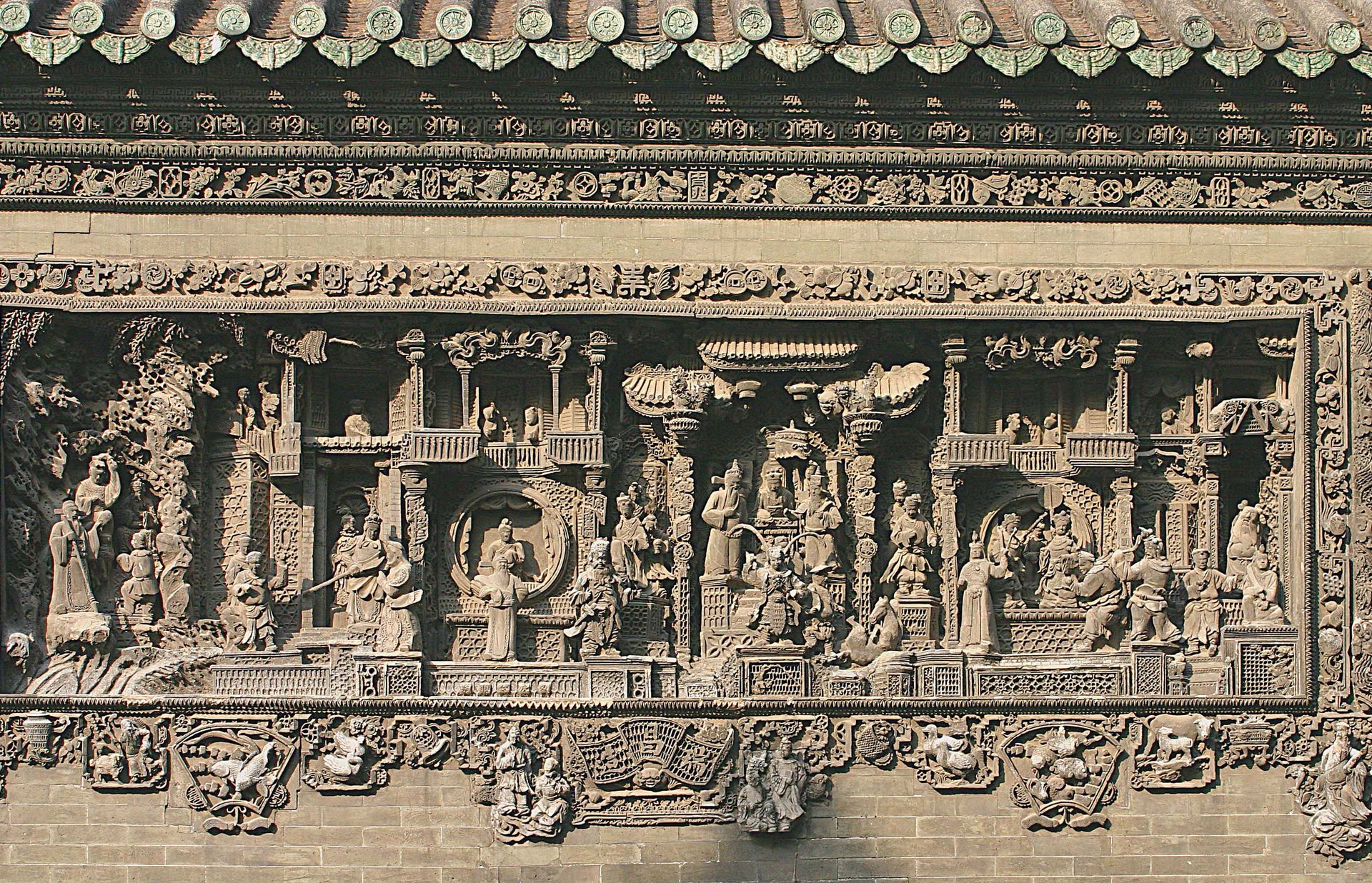 Detailed brick relief with figures, trees, and architecture at Chen Clan Ancestral Hall